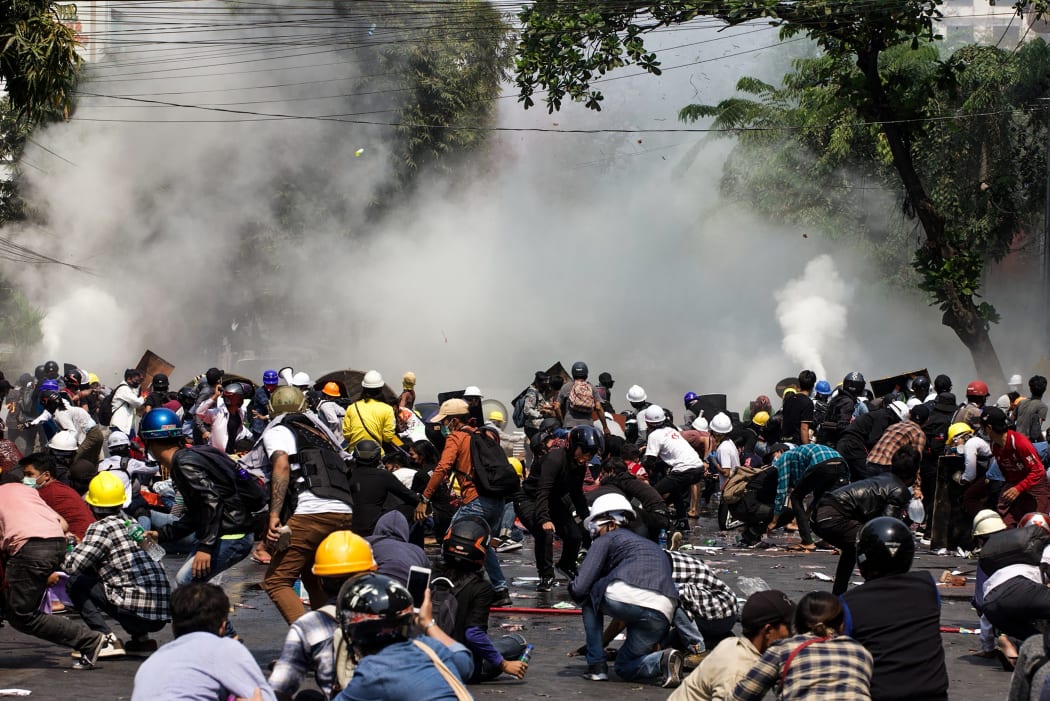 Protesters react after police fired tear gas during a demonstration against the military coup in Mandalay on 3 March