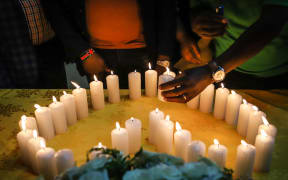 Relatives of victims, who perished among the 157 passengers and crew onboard the Ethiopian Airlines operated Boeing 737 MAX 8 aircraft, light candles during a memorial service at the Kenyan Embassy in Addis Ababa, on March 16, 2019.