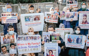 Members of the Muslim Uighur minority hold placards as they demonstrate in front of the Chinese consulate on 30 December 2020, in Istanbul, to ask for news of their relatives and to express their concern after China announced the ratification of an extradition treaty with Turkey.