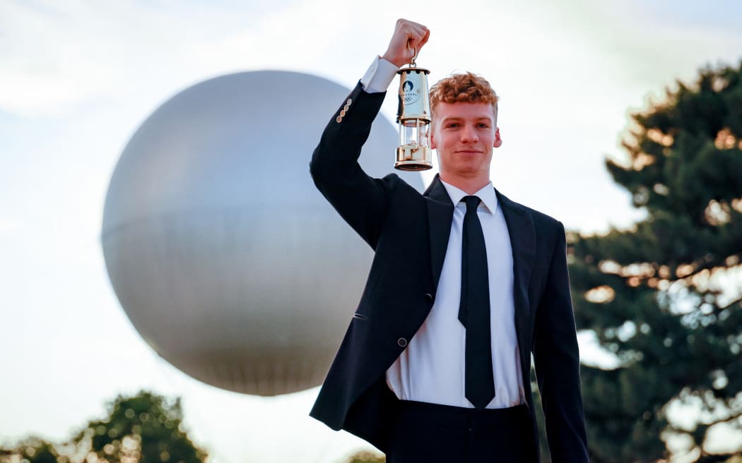 Leon Marchand with Olympic flame during Closing Ceremony of the Olympic Games Paris 2024, at Jardin des Tuileries, in Paris, France, on August 11, 2024, Photo KMSP / KMSP (Photo by AGENCE KMSP / KMSP / KMSP via AFP)