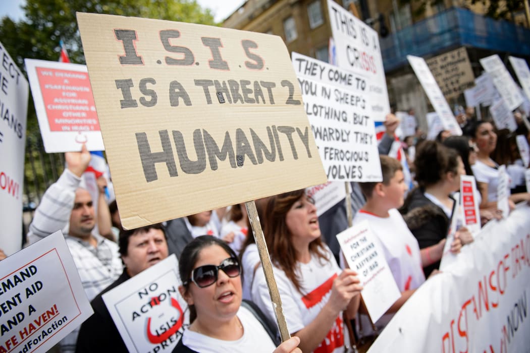 Demonstrators hold placards as they protest against the actions of Islamic State in Iraq outside Downing Street in central London.