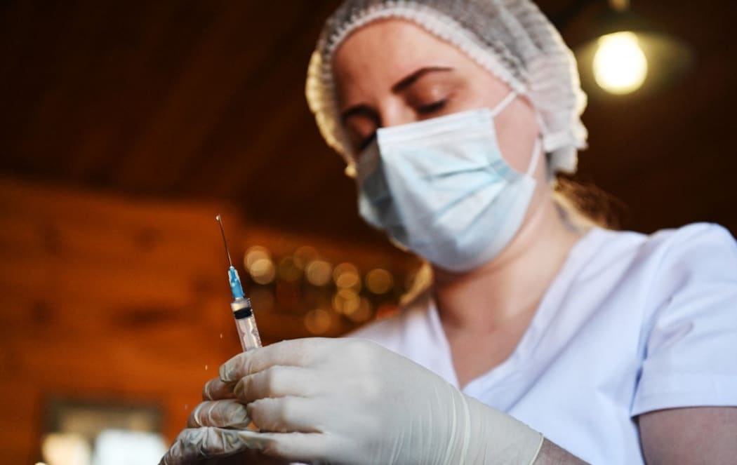 A medical worker vaccinates an employee of the Olympic Reserve Equestrian Sports School against COVID-19 in Novosibirsk, Russia.