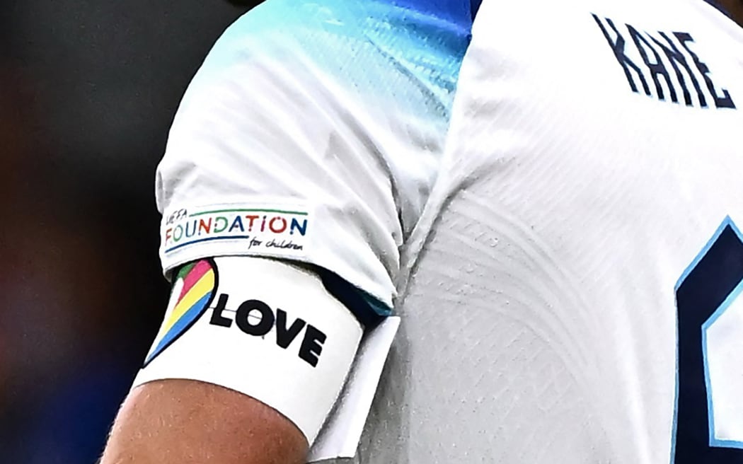 In this file photo taken on September 24, 2022, England's forward Harry Kane, wearing a rainbow armband, reacts after losing the UEFA Nations League's League A Group 3 match between Italy and England, at the San Siro Stadium in Milan. - England, Germany and five other European teams at the World Cup on Monday, November 21, abandoned plans to wear a rainbow-themed armband in support of LGBTQ rights, citing the threat of disciplinary action from FIFA.