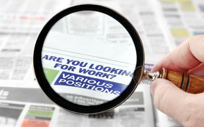 Magnifying glass on job ads.