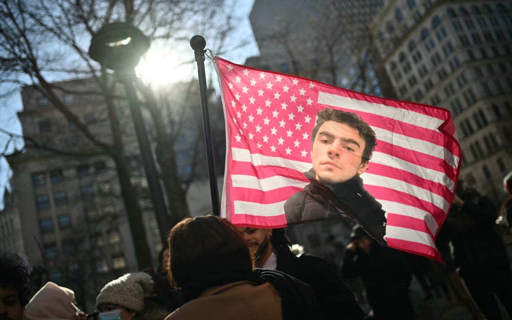 Protesters hold signs outside the Criminal Court where Luigi Mangione, accused killer of US insurance CEO Brian Thompson, attends a hearing in New York City on February 21, 2025. Mangione is accused of gunning down Thompson in a brazen hit in New York on December 4, 2024, pleaded not guilty to state charges including "terrorist" murder. The suspect is charged in both state and federal court. (Photo by ANGELA WEISS / AFP)
