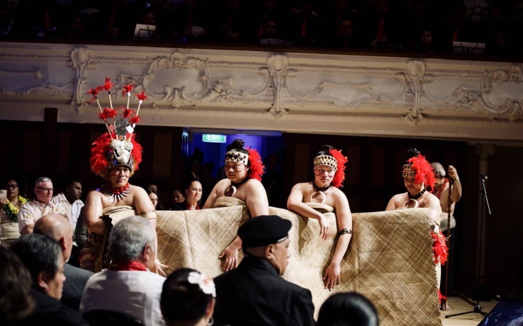 McAuley High School students gifting a Ie Toga or fine mat during the formal part of the Dawn Raids apology.