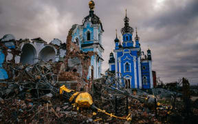 Construction workers climb onto the roof of a destroyed church in the village of Bohorodychne, Donetsk region on January 4, 2023, amid the Russian invasion of Ukraine. - Bohorodychne is a village in Donetsk region that came under heavy attack by Russian forces in June 2022, during the Russian invasion of Ukraine. On August 17, 2022 the Russian forces captured the village. The Armed Forces of Ukraine announced on September 12, 2022 that they took back the control over the village. A few resident came back to restore their destroyed houses and live in the village. (Photo by Dimitar DILKOFF / AFP)