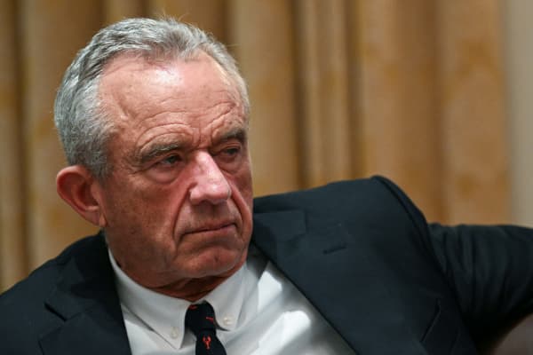 Robert F Kennedy Jr - a 71 year old man with cropped grey hair - wears a suit and looks to the side.