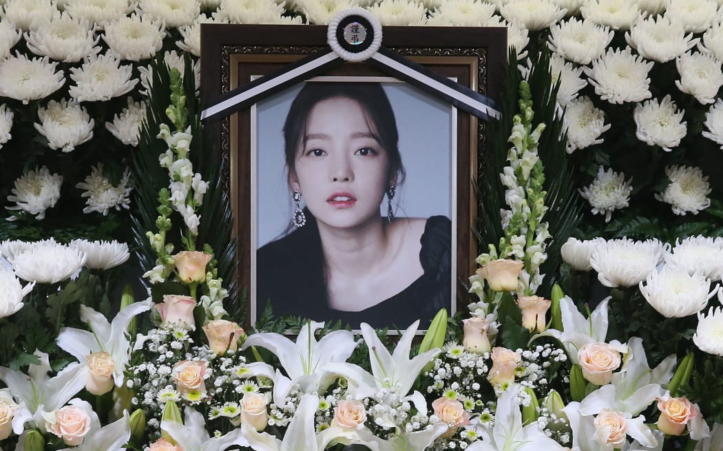The portrait of late K-pop star Goo Hara is seen surrounded by flowers at a memorial altar at a hospital in Seoul on November 25, 2019. - Fans mourned and questions were asked November 25 after K-pop star and revenge porn victim Goo Hara was found dead in a possible suicide, which would make her the second female singer in a month to take her own life in the high-pressure industry. (Photo by str / Dong-A Ilbo / AFP) / South Korea OUT