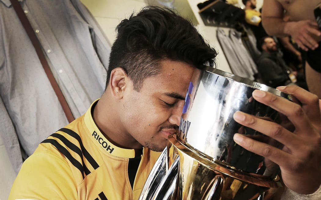 Julian Savea hugs the Super Rugby trophy 2016.