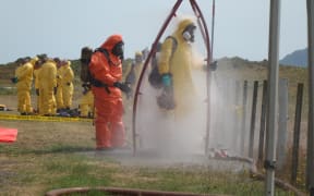 Recovery teams wash off toxic residues after their mission to Whakaari/White Island.