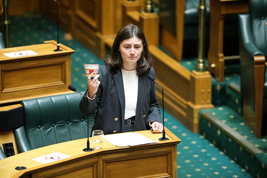 Green MP Chloe Swarbrick holds up a cup of instant noodles as an example of what students can afford to eat once they've paid for living costs