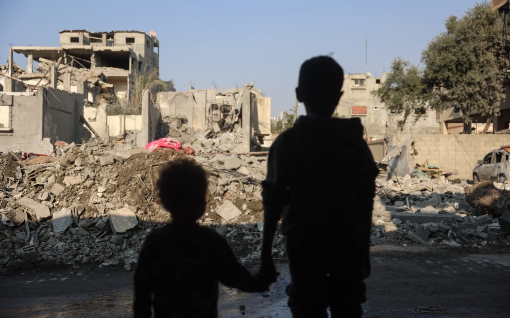 Children stare at the destruction following an Israeli strike in the Nuseirat refugee camp in the central Gaza Strip on November 7, 2024, amid the ongoing war between Israel and Palestinian Hamas militants. (Photo by Eyad BABA / AFP)