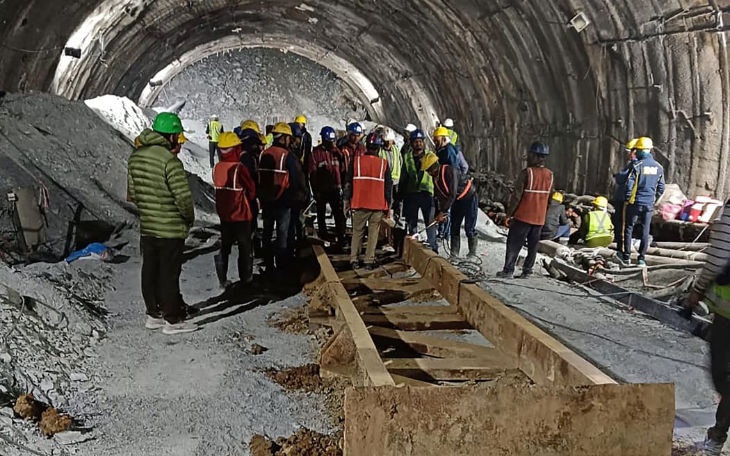 This handout photo taken on November 13, 2023, and released by the State Disaster Response Force (SDRF) shows rescue workers at the site after a tunnel collapsed in the Uttarkashi district of India's Uttarakhand state. More than a hundred rescuers in northern India struggled for a third day on November 14 to save workers trapped underground after the road tunnel they were building collapsed. (Photo by State Disaster Response Force (SDRF) / AFP) / RESTRICTED TO EDITORIAL USE - MANDATORY CREDIT "AFP PHOTO/State Disaster Response Force (SDRF)" - NO MARKETING NO ADVERTISING CAMPAIGNS - DISTRIBUTED AS A SERVICE TO CLIENTS