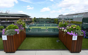 A photograph taken on June 24, 2025 shows planter separating TV crews on the roof of the broadcast centre in the grounds of the All England Lawn Tennis & Croquet Club in Wimbledon, south west London. Wimbledon head gardener Martyn Falconer is the only man at the All England Club who welcomes a spot of rain during Wimbledon tennis tournament to help keep his flowers in tip-top shape. He oversees the delivery of 27,000 plants specifically for the Championships in leafy southwest London to add to thousands already in place in the immaculate grounds. (Photo by GLYN KIRK / AFP)