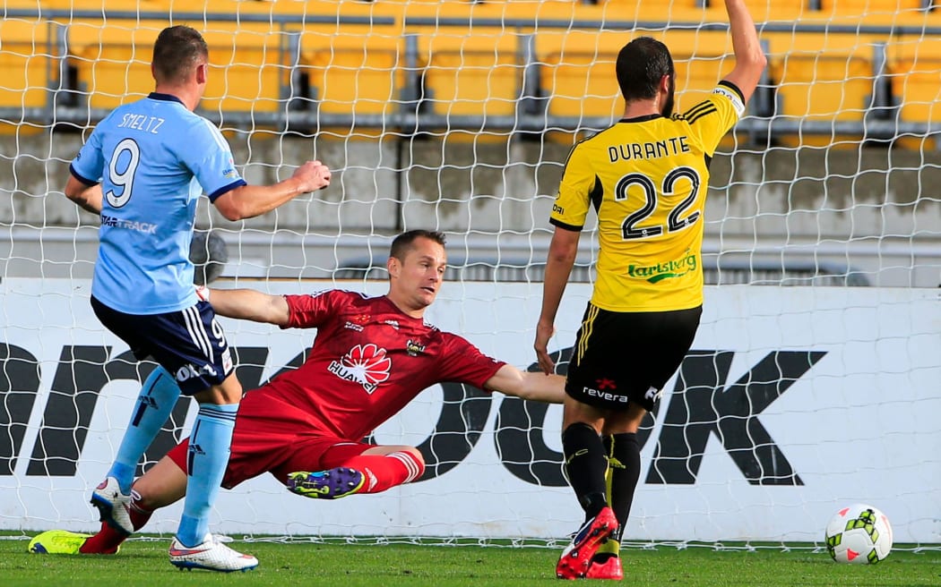 Sydney FC's Shane Smeltz slots the ball past Phoenix's Glen Moss