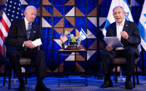 (FILES) US President Joe Biden listens to Israel's Prime Minister Benjamin Netanyahu as he reads a statement in Tel Aviv on October 18, 2023, amid the battles between Israel and the Palestinian group Hamas. Hamas's unprecedented attack on Israel on October 7, 2023 which left about 1,140 dead in Israel, mostly civilians, according to an AFP tally based on official figures, and saw 250 hostages dragged back into Gaza sparked the war which is still raging in the besieged Gaza Strip. After almost 100 days of war, at least 23,357 people have been killed in the fighting, the majority of them women and children, according to the Hamas health ministry -- or almost one percent of the population. (Photo by Brendan Smialowski / AFP)