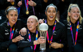 New Zealand captain Laura Langman holds the Netball World Cup trophy  with Maria Folau, Phoenix Karaka and Shannon Saunders after victory over Australia.