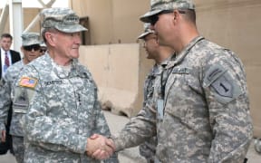 Martin Dempsey shakes hands with US service members in Baghdad, Iraq.