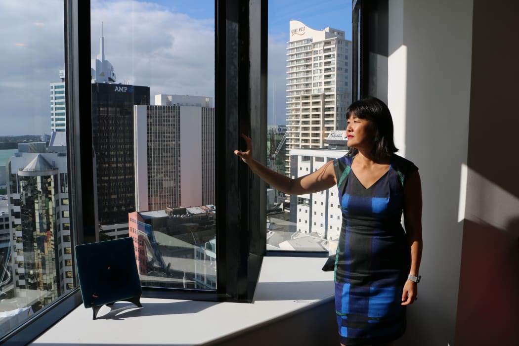 Woman looking out a high rise window