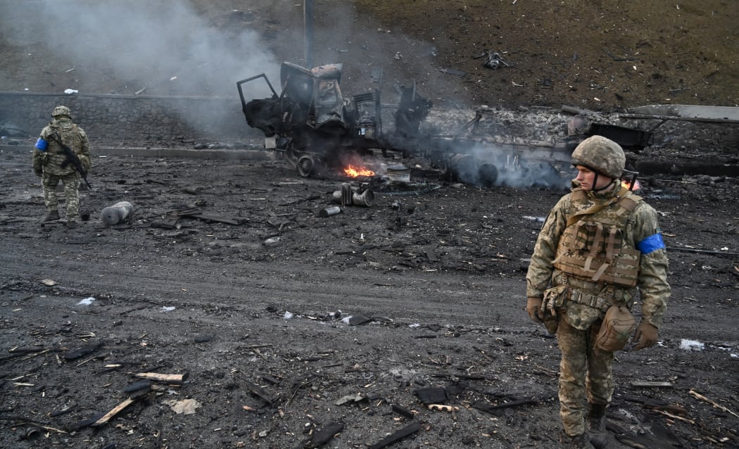 Ukrainian service members look for unexploded shells after a fighting with Russian raiding group in the Ukrainian capital of Kyiv in the morning of February 26, 2022.