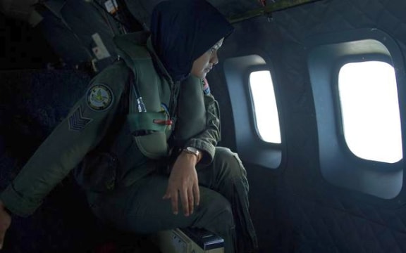 A crew member on a Malaysian Air Force CN235 aircraft searching for missing Malaysia Airlines flight MH370 over the Strait of Malacca.