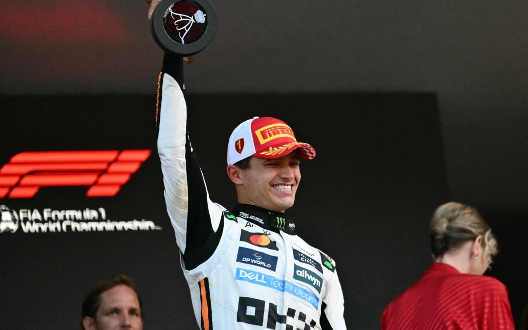 McLaren's British driver Lando Norris lifts the trophy on the podium after winning the Formula One Monaco Grand Prix at the Circuit de Monaco, on May 25, 2025.