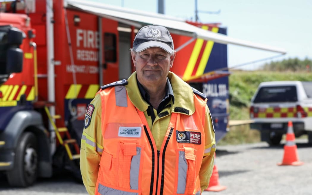 Brian Keown, incident commander standing i front of a fire engine.