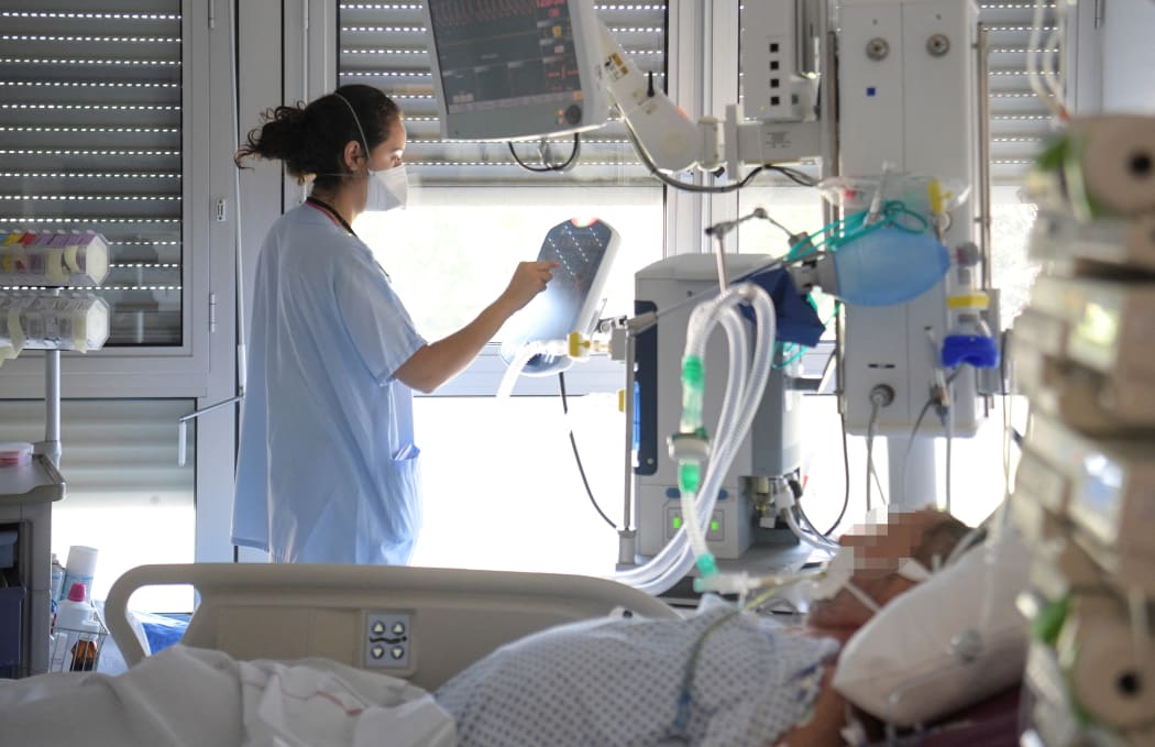 A medical staff takes care of a non-Covid-19 patient in the intensive care unit of the Emile Muller hospital in Mulhouse, eastern France, on July 23, 2021. (Photo by SEBASTIEN BOZON / AFP)