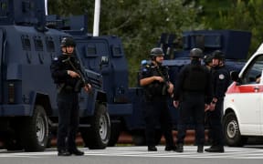 Kosovo's police officers stand guard at the entrance of the village of Banjska on September 24, 2023, after one policeman was killed and another wounded in north Kosovo early Sunday. According to authorities, the incident occurred during an armed attack on a police patrol as it approached a blocked road near the border with Serbia. (Photo by STRINGER / AFP)