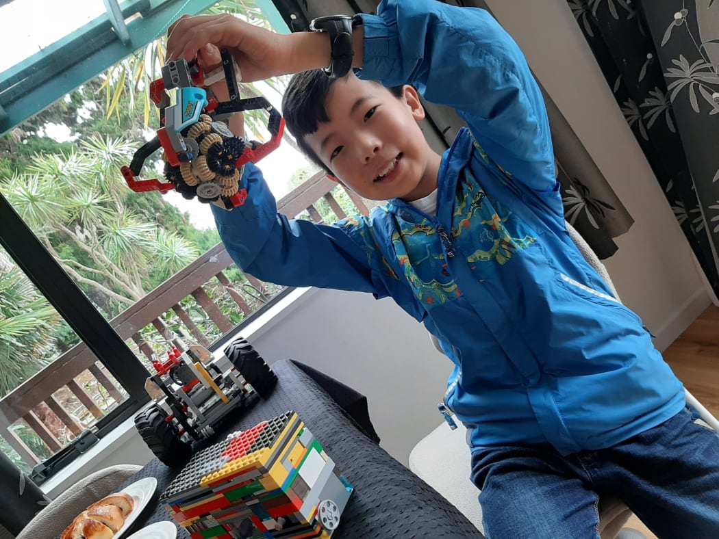 Dingding holds up his Lego creations