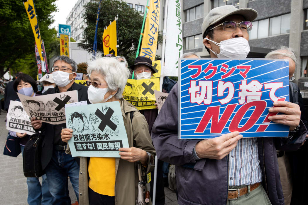 Demonstrators hold slogans during a protest outside the Japanese prime minister's office against the government's plan to release treated water from the Fukushima nuclear plant into the ocean, on April 13, 2021.