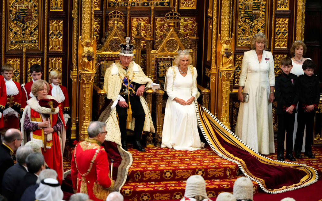 Britain's King Charles III, wearing the Imperial State Crown and the Robe of State, sits alongside Britain's Queen Camilla, wearing the George IV State Diadem, as he prepares to read the King's Speech from the The Sovereign's Throne in the House of Lords chamber, during the State Opening of Parliament, at the Houses of Parliament, in London, on July 17, 2024.