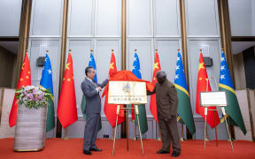 Wang Yi, China's Foreign Affairs minister and Manasseh Sogavare, the prime minister of Solomon Islands, jointly unveil the nameplate of the Solomon Islands embassy in Beijing.