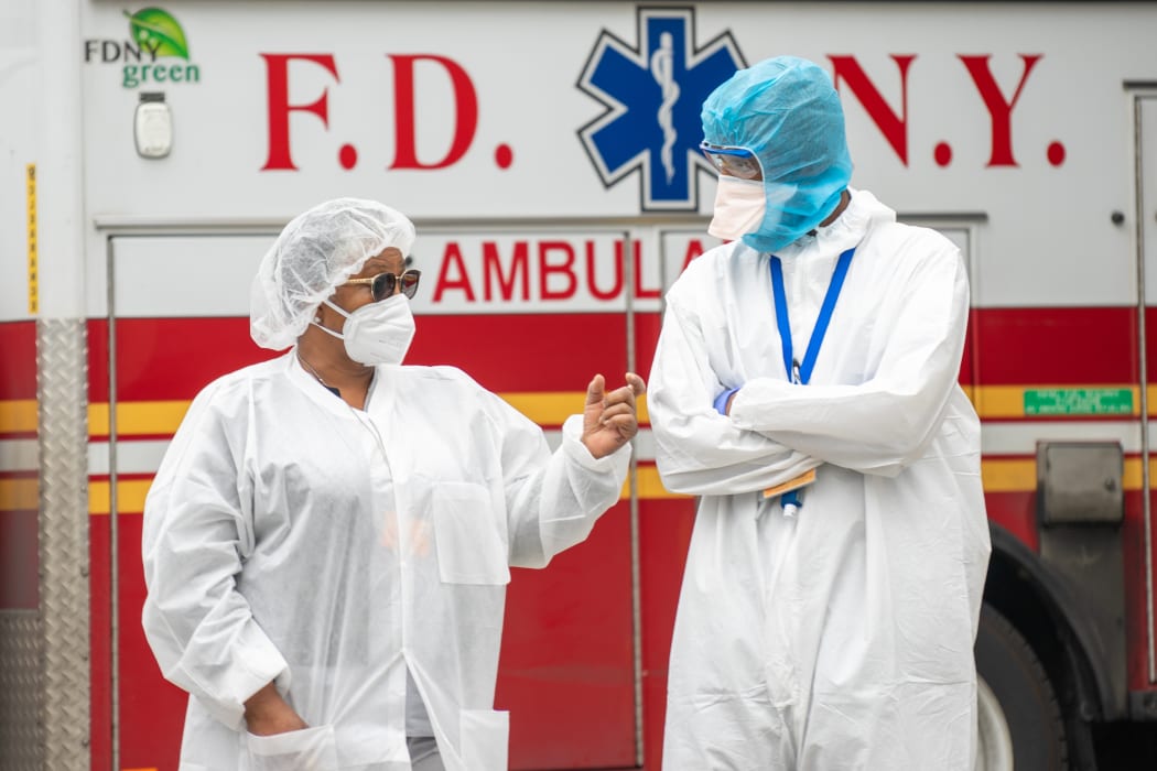 Bronx-Lebanon Hospital Center medical staff speak to each other outside of the emergency room bay in New York City.