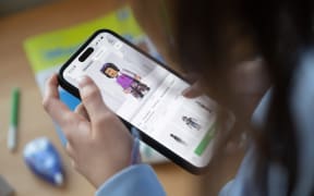 ILLUSTRATION - 20 November 2024, Baden-Württemberg, Stuttgart: A girl operates a smartphone on which the Roblox app can be seen (posed scene). Photo: Marijan Murat/dpa (Photo by MARIJAN MURAT / dpa Picture-Alliance via AFP)
