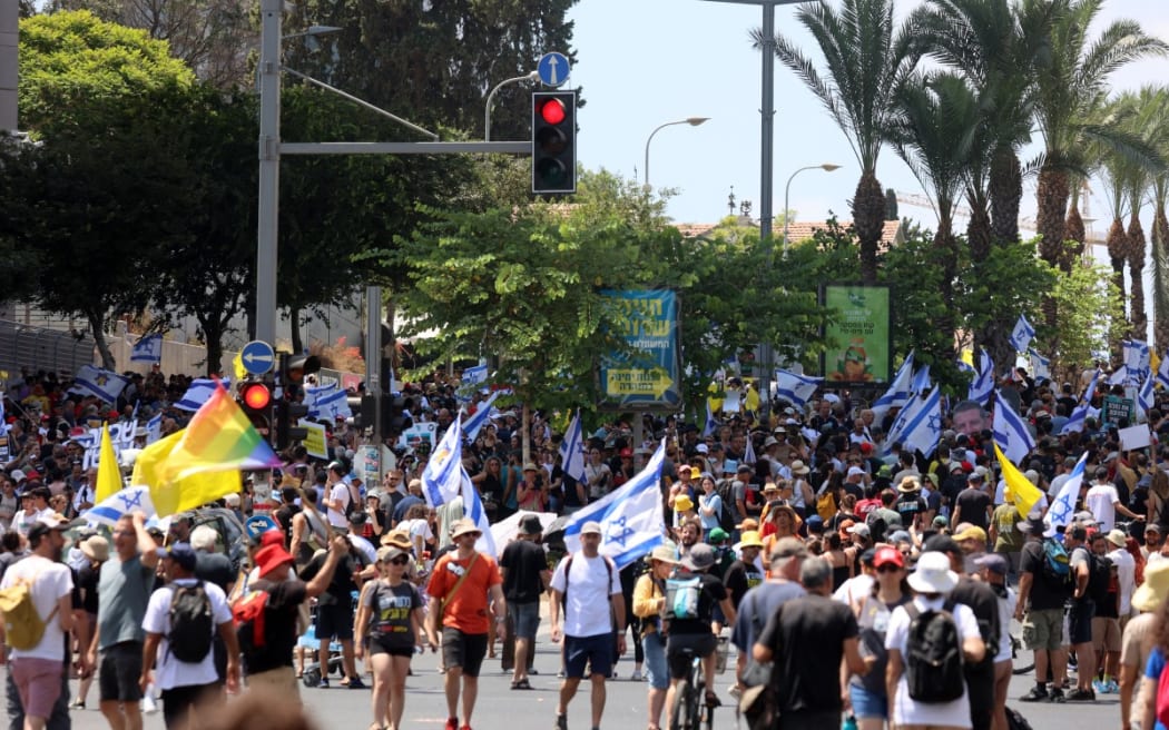 Demonstrators raise flags during an anti-government protest demanding a deal to release Israelis detained in the Gaza Strip by Hamas militants since October 7, 2023, in Tel Aviv on August 17, 2025.