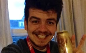 A picture of Joseph Moore with a World Cup commemorative beer