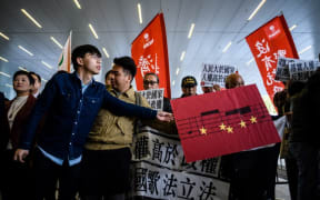 Hong Kong pro-democracy activist Joshua Wong (L)  during a protest outside the Legislative Council, against a proposed law to punish anyone who disrespects the Chinese anthem with up to three years in jail.