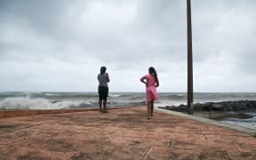 People look at the ocean in Basse-Terre, on the Fench Caribbean island of Guadeloupe, as Hurricane Maria approaches the Caribbean.