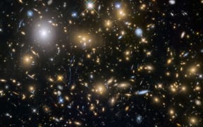 Astronomers use the Hubble Space Telescope and Albert Einstein's General Theory of Relativity to obtain gravitational lensing images of galaxy cluster.