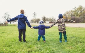 three kids holding hands