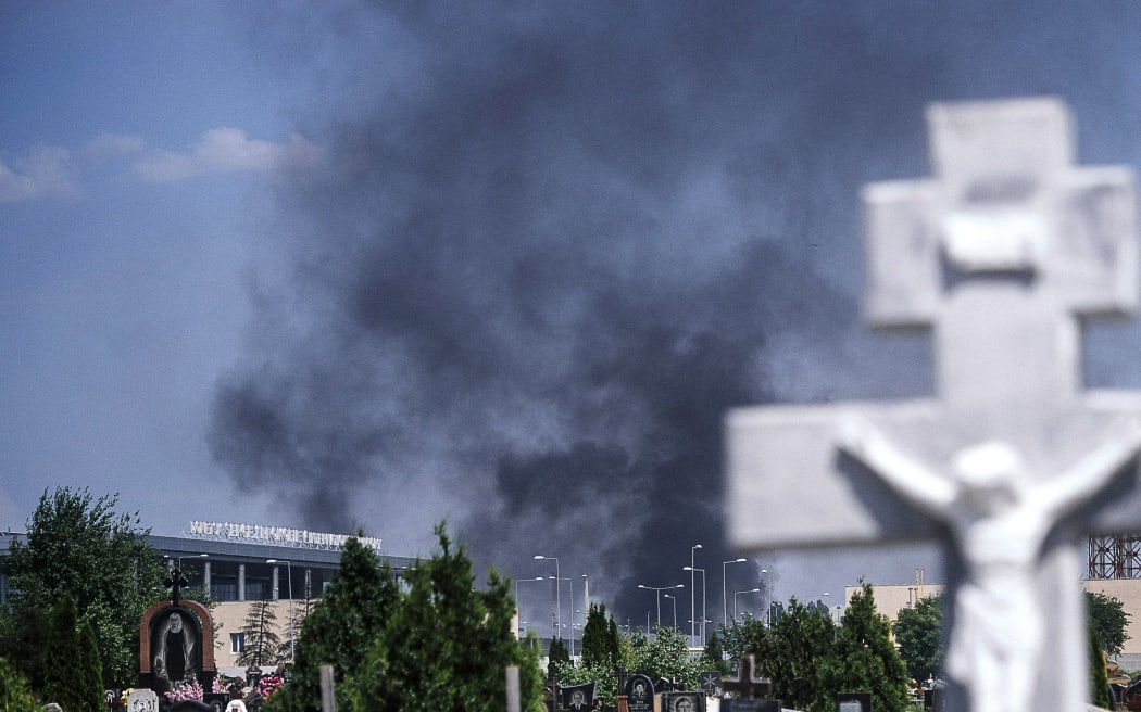 Black smoke billows from Donetsk international airport, seen beyond a cemetery, on Monday.