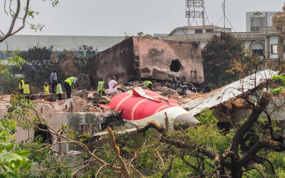 An investigation team inspects the wreckage of Air India flight 171 a day after it crashed in a residential area near the airport, in Ahmedabad on 13 June, 2025. Investigators recovered a black box recorder from the crash site.
