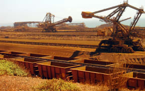 (FILES) This file photo taken on March 4, 2010 shows remote-controlled stackers and reclaimers moving iron ore to rail cars at Rio Tinto's Port Dampier operations in Western Australia's Pilbara region.