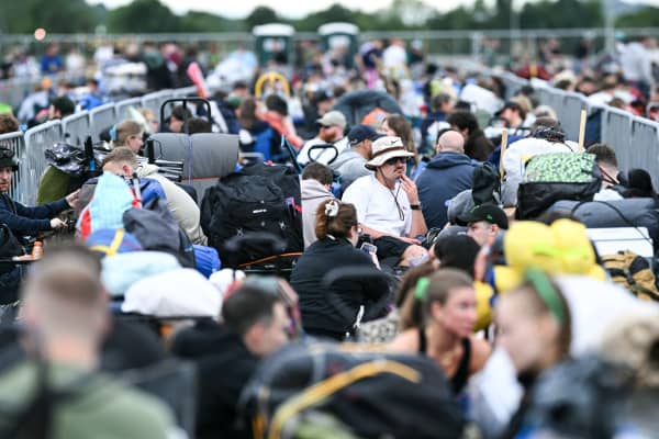 Festival goers queue upon their arrival to attend the first day of the Glastonbury festival at Worthy Farm in the village of Pilton in Somerset, southwest England, on June 25, 2025.