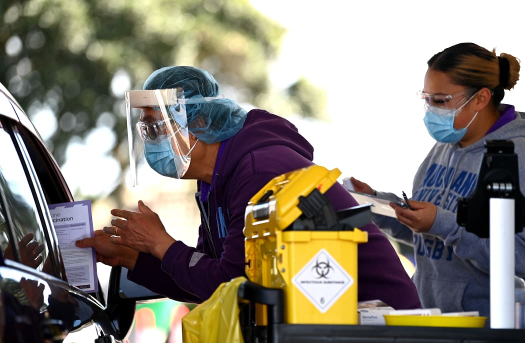 AUCKLAND, NEW ZEALAND - SEPTEMBER 25: A nurse hands out information after vaccinating a member of the public in their car during the Cook Islands drive through vaccination community event on September 25, 2021 in Auckland,