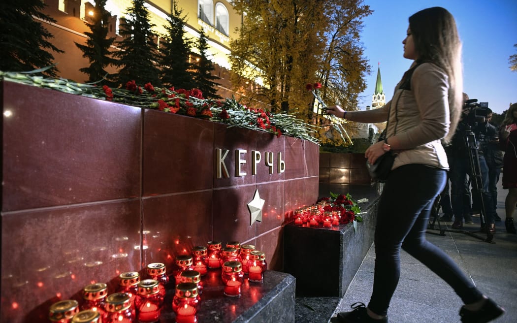 A woman lays flowers at the WWII Hero Cities Memorial to the city of Kerch in downtown Moscow.