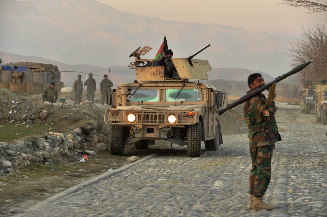 An Afghan security force soldierholds a rocket-propelled grenade near the site of a car bomb attack in Sherzad district of Nangarhar Province, 30 January 2021.