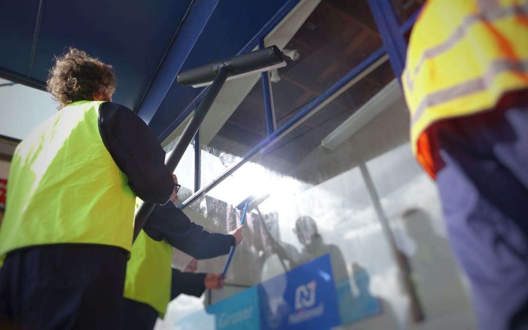 TPP protest group "Show Us Ya Text" at Trade Minister Tim Groser's office in Auckland, washing his windows in a symbolic push for more transparency.